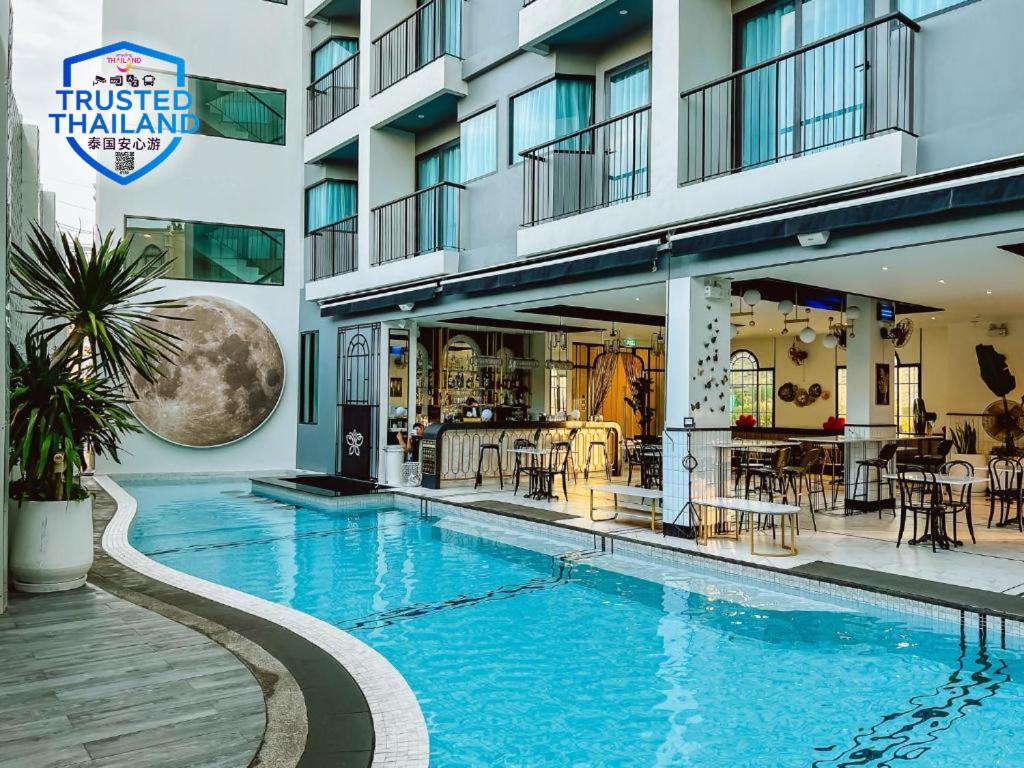 a hotel with a swimming pool in front of a building at Ratri Hotel Phuket Old Town in Phuket Town