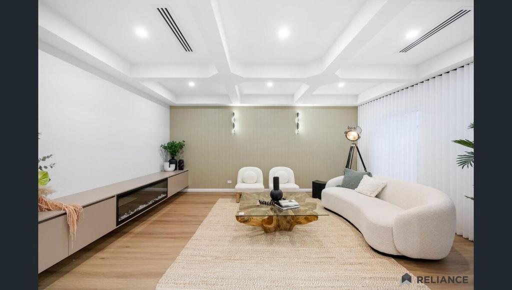 Sunbury home close to Melbourne airport في صَنبري: غرفة معيشة بها أريكة وطاولة