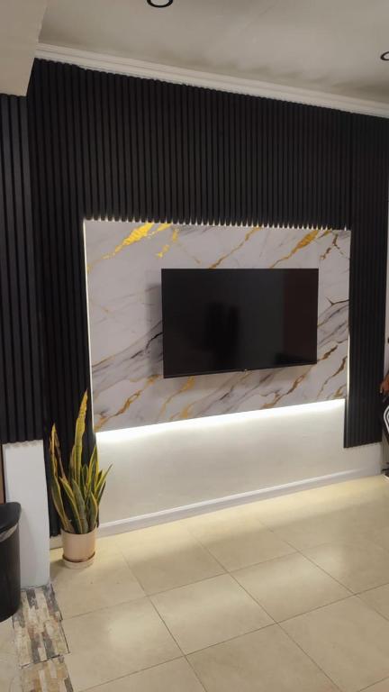 a living room with a large wall mounted television at Jazmin's Apartments in Oranjestad