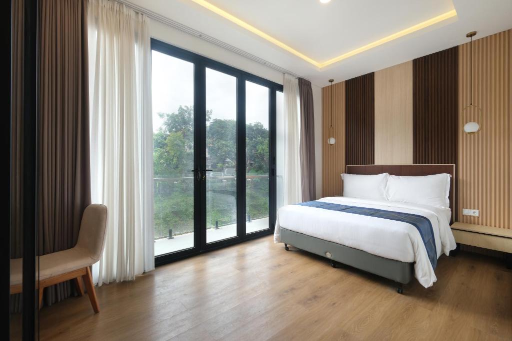 a bedroom with a bed and a large window at Bellevue Villa Canggu in Canggu