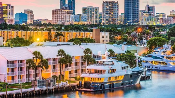 a group of boats docked at a marina with a city at Cozy Little Bungalow in Fort Lauderdale