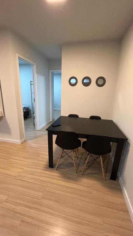 a dining room with a table and two clocks on the wall at Apto moderno e aconchegante in Ponta Grossa