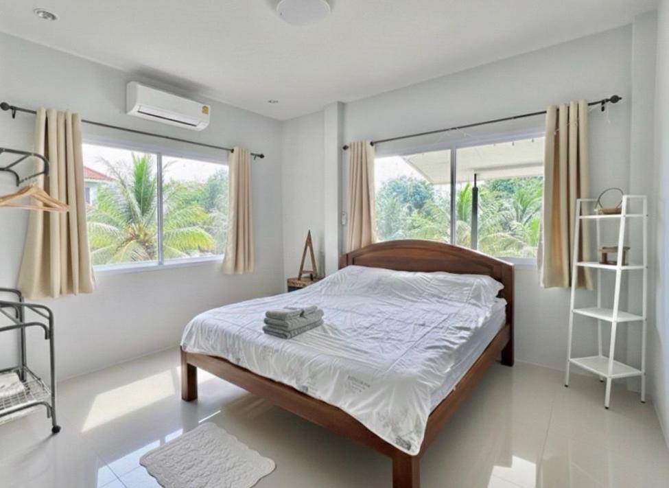 ein Schlafzimmer mit einem Bett und einem großen Fenster in der Unterkunft Chon Nara Place in Thongsala