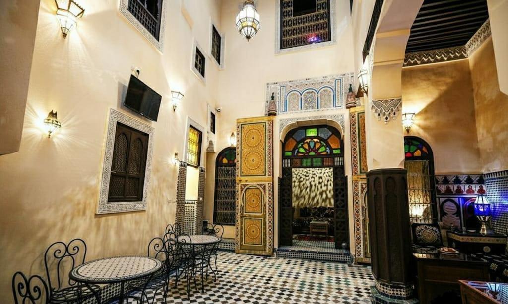 a room with tables and chairs and a large door at Riad Fez Panorama in Fès