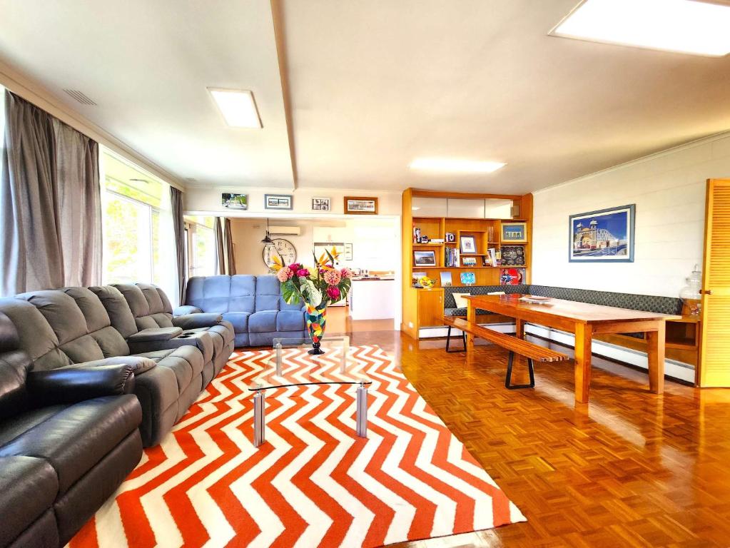 una sala de estar con un sofá y una mesa en Private quad guest room 3 with free parking, en Highett