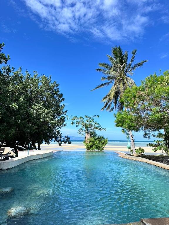 a pool of water in front of a beach at Sama Beach Resort by Munchies Resort in Ban Tai