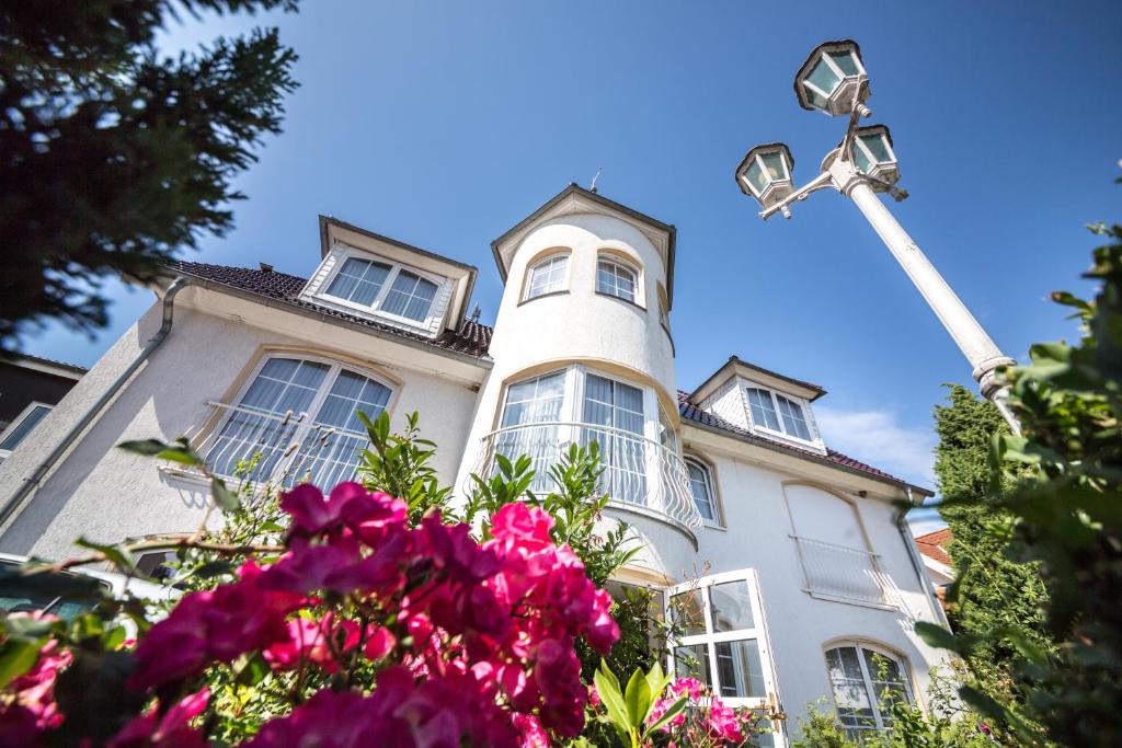 a white house with flowers in front of it at ArtHotel mare in Scharbeutz