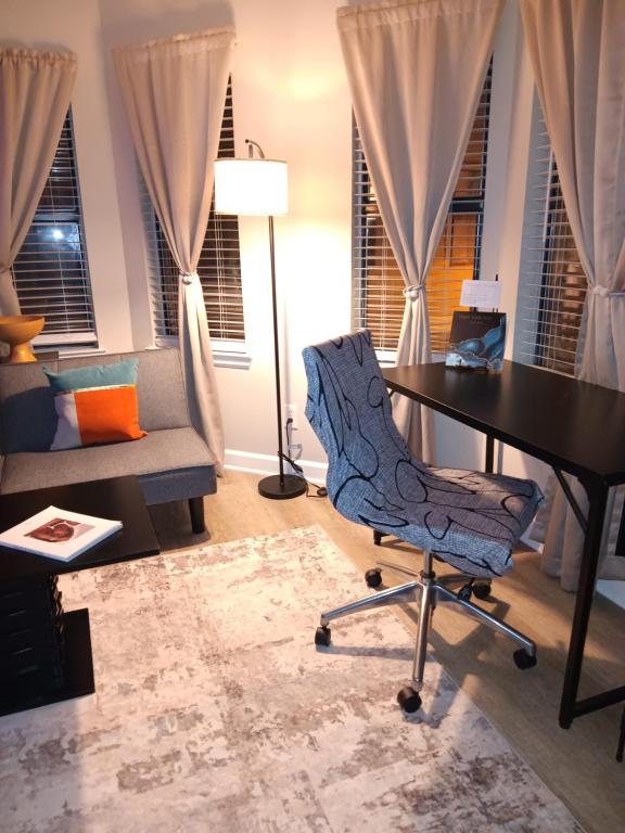 The Serene Uptown Flat في تشارلوت: غرفة معيشة مع مكتب وكرسي