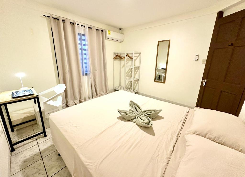 a bedroom with a white bed with a flower on it at Casa Maya Guesthouse in Mal País