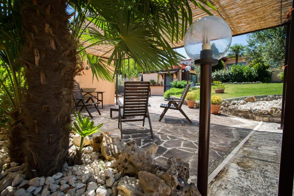 een patio met stoelen en een palmboom bij Il Viottolo in Noci
