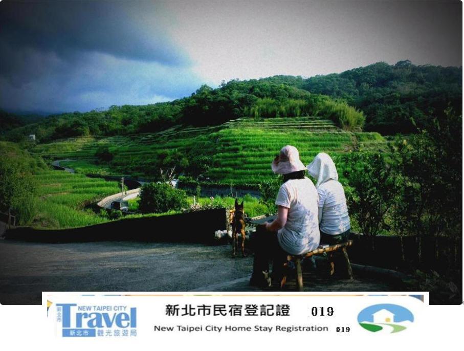 dos personas sentadas en un banco mirando a una montaña en Emoonten Homestay, en Sanzhi