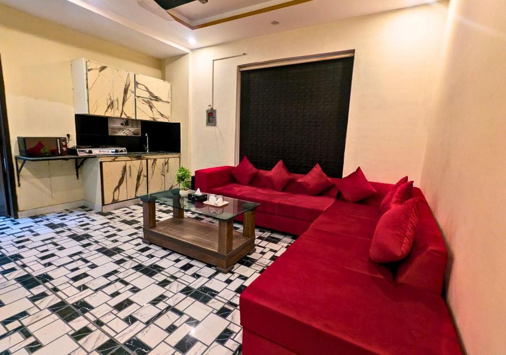 ein Wohnzimmer mit einem roten Sofa und einem Tisch in der Unterkunft Hayat Lodges & Hotel in Lahore