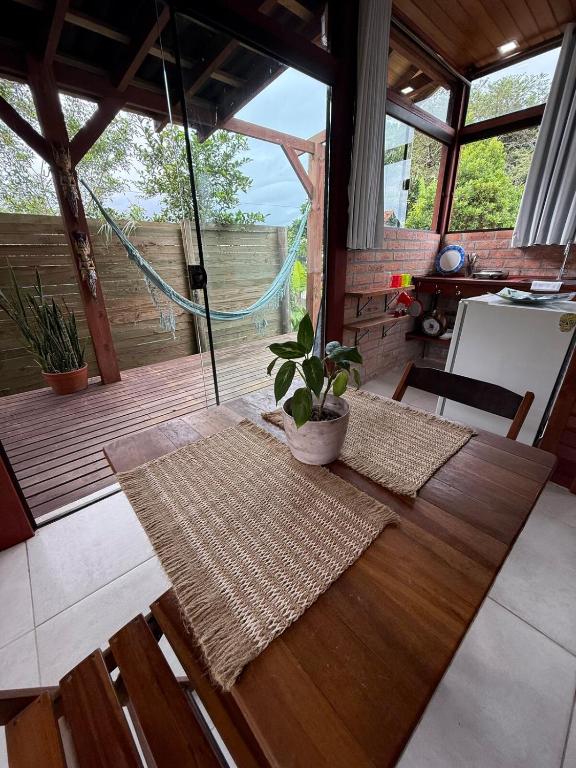 een kamer met een houten tafel en een potplant bij Loft no centrinho do Rosa in Imbituba