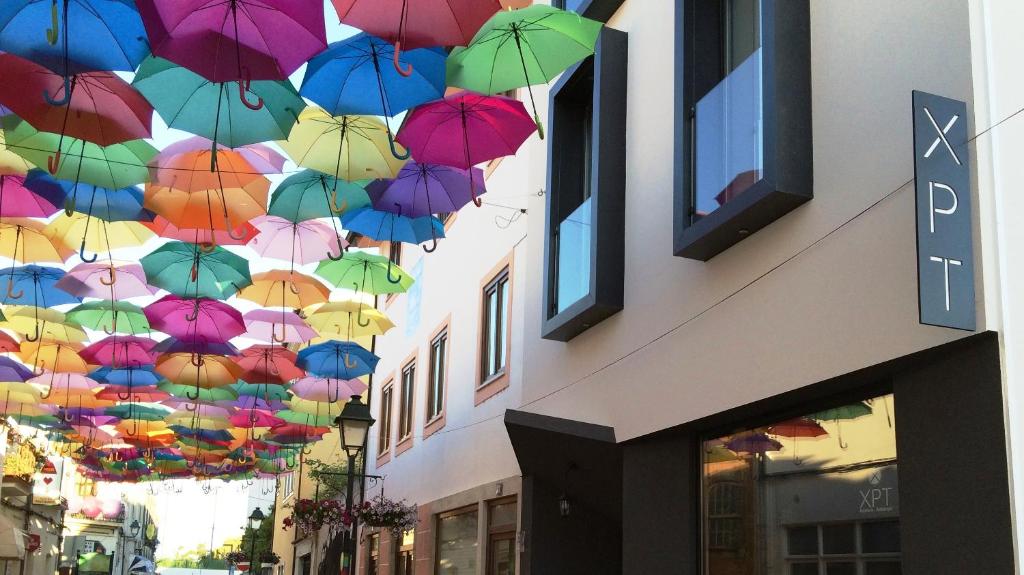 Un mucchio di ombrelli colorati appesi a un edificio di XPT Águeda - Alojamento Local ad Águeda
