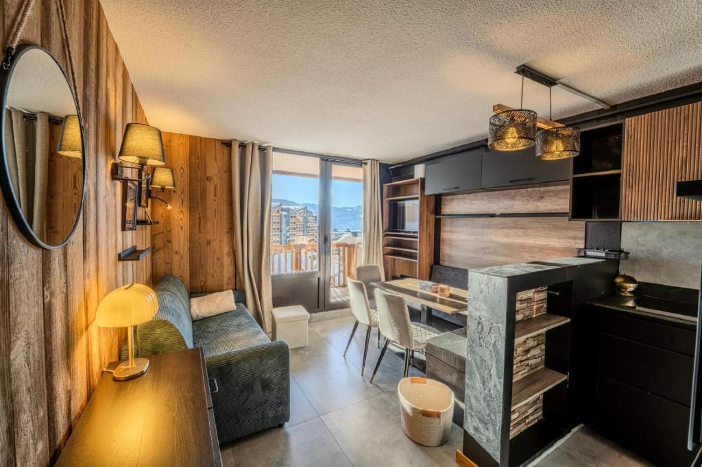 a living room with a table and a dining room at Val Thorens Cosy Pieds des pistes Centre Val Thorens 2 chbres in Val Thorens