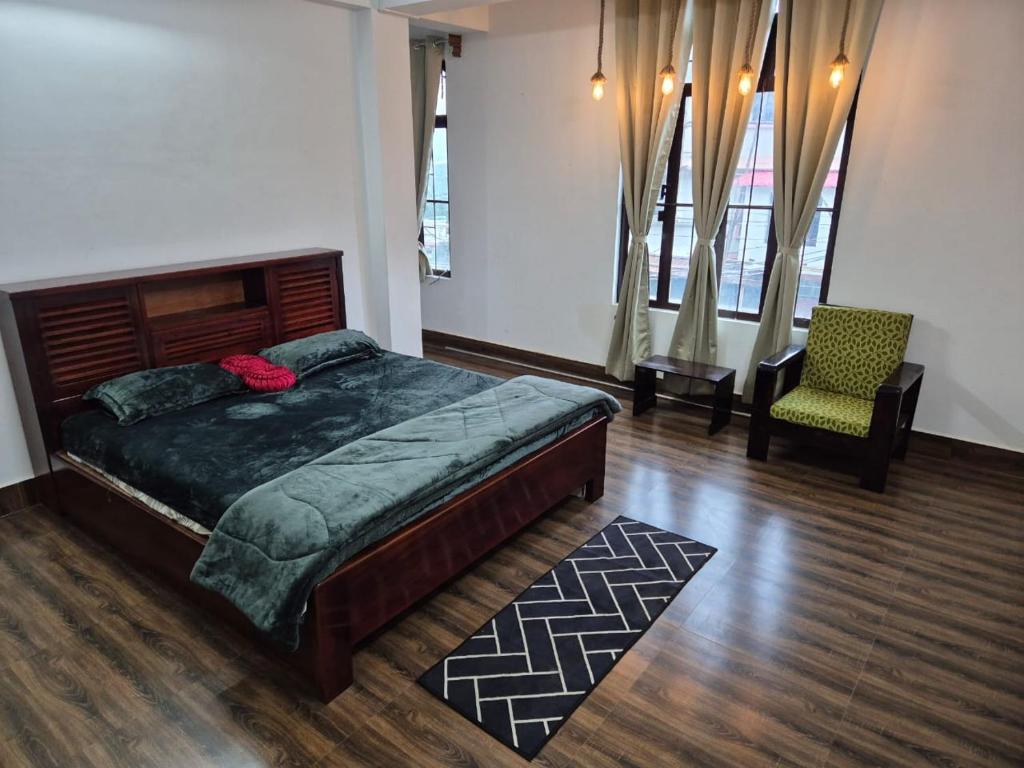 ein Schlafzimmer mit einem großen Bett und einem Stuhl in der Unterkunft Hornbill Homes 1 in Kohīma