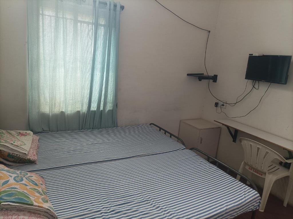 Ένα ή περισσότερα κρεβάτια σε δωμάτιο στο chenniyappa lodge