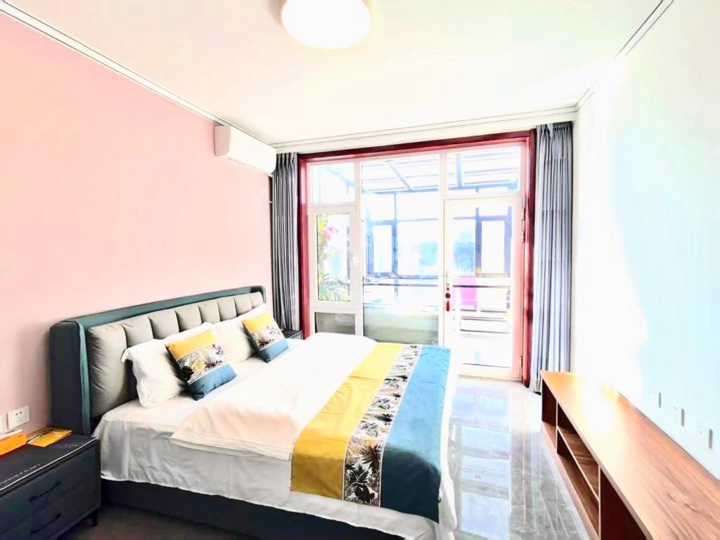 a bedroom with a bed and a large window at 金山岭 古北口长城 聚友缘精品民宿 in Gubeikou