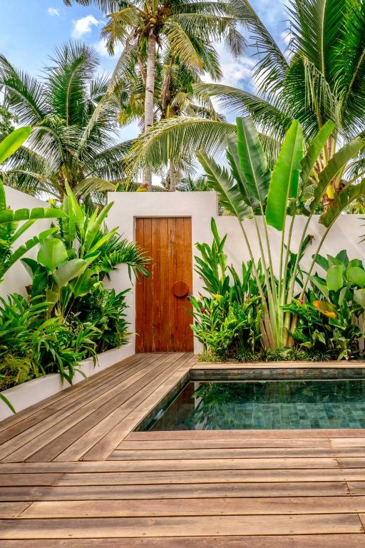 a wooden pathway leading to a villa with a wooden door at Manao Villas - Luxury Boutique Resort in General Luna