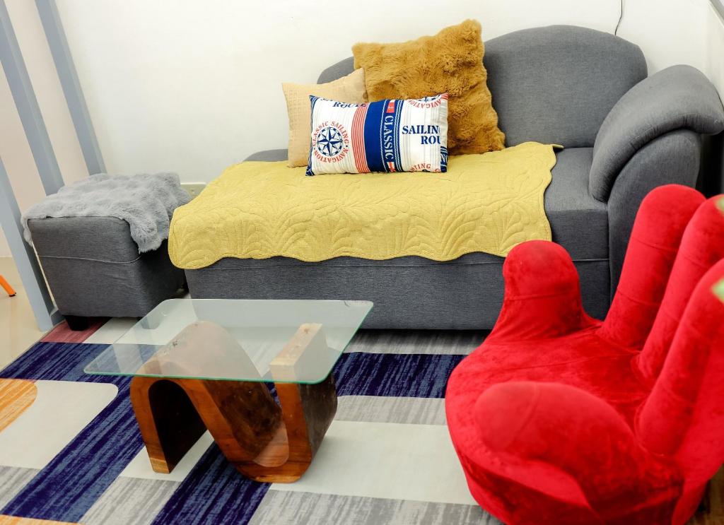 a living room with a couch and a red chair at Clark Stays Yellow in Iba