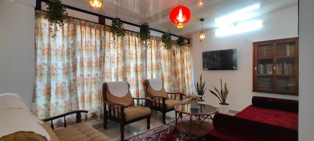 a living room with a couch and chairs and a table at Anaaya Riverside Nest in Jāmb