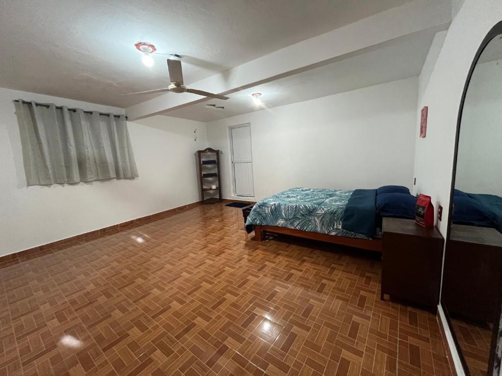 a bedroom with a bed and a wooden floor at Posada Oasis in Cuetzalán del Progreso