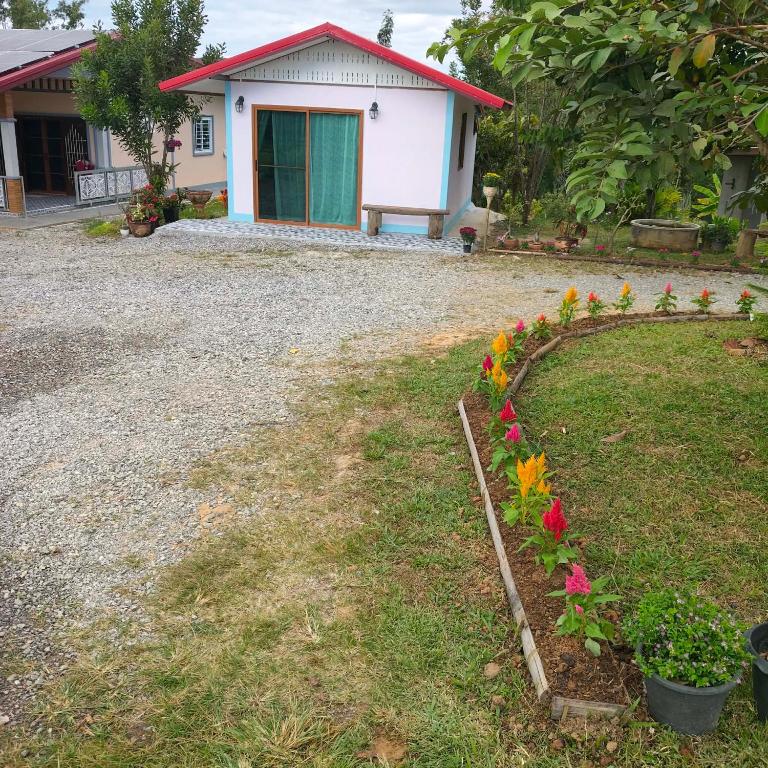 a house with a garden with flowers in the yard at RATTHANATHON Farm in Khao Kho