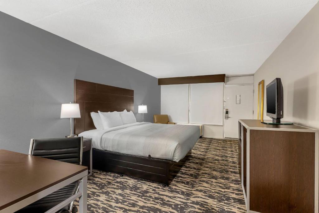 a hotel room with a bed and a flat screen tv at Quality Inn & Suites Easley - Greenville in Easley