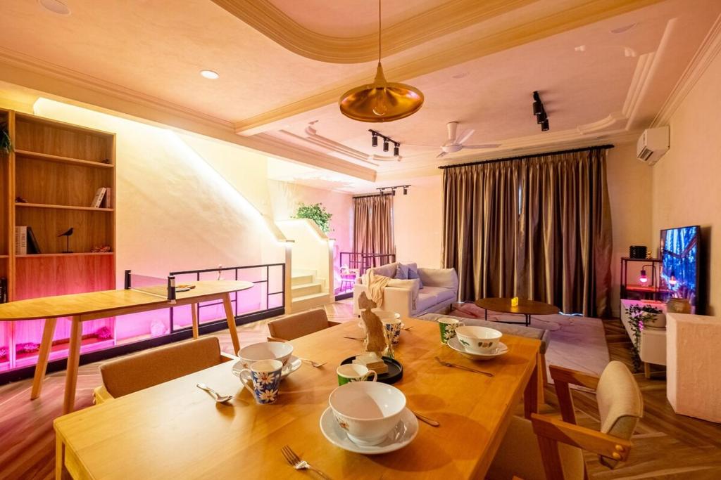 a living room with a wooden table and chairs at Tere Home Landed Stylish&Warm Flamingo Pinky House in Shah Alam