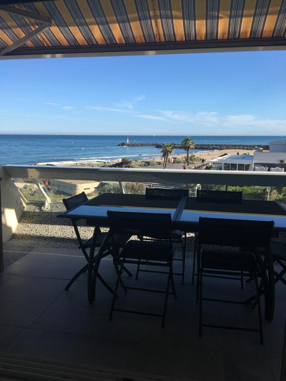 a table and chairs on a balcony with a view of the ocean at Elixxir in Cap d'Agde