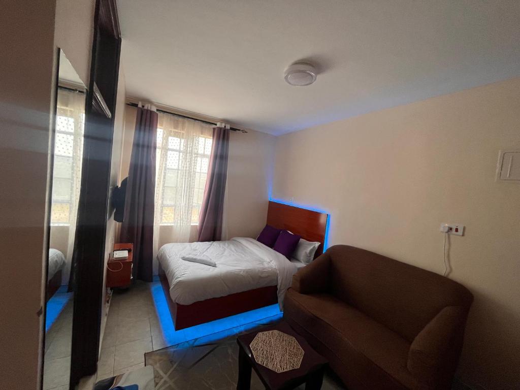 MachakosにあるPearl Studioのベッドと椅子のある小さな寝室
