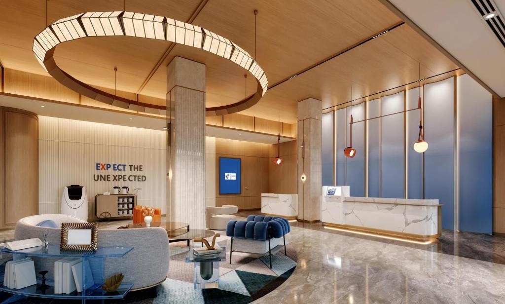 a lobby with a couch and chairs and a table at Holiday Inn Express Qingdao Downtown by IHG in Qingdao