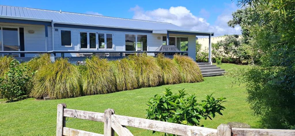 een huis met een hek voor een tuin bij A Waihi Beach Getaway in Waihi Beach