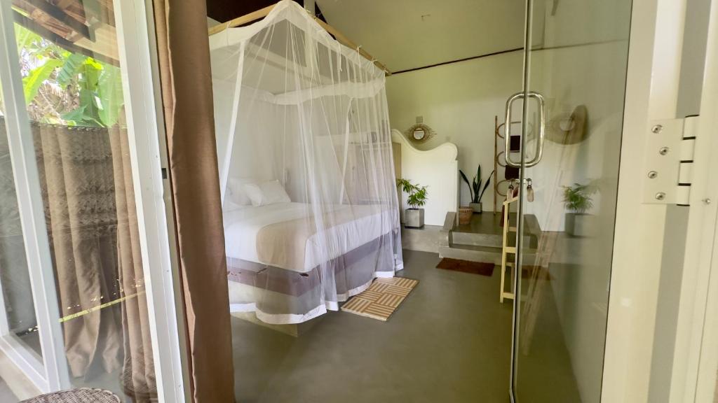 a bedroom with a bed and a glass shower at Sjæl - Surf, Stay and yoga in Dickwella