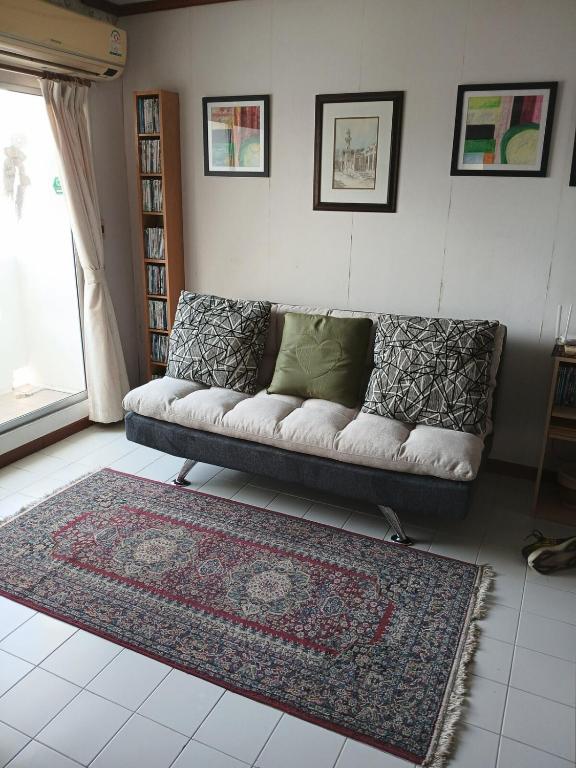 a living room with a couch and a rug at Great Value Residence in Bangna