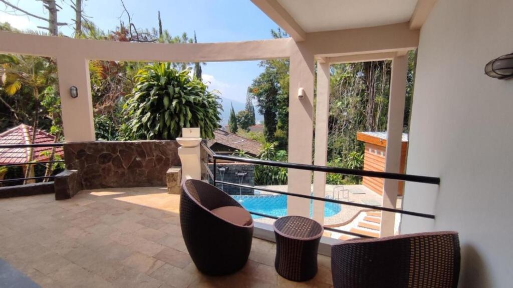 a balcony with chairs and a view of a pool at Rumah Kolam Pribadi in Punten