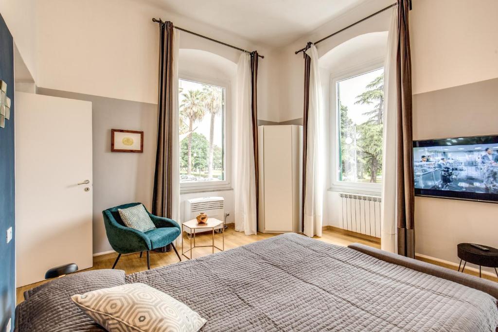 Schlafzimmer mit einem Bett, einem TV und einem Stuhl in der Unterkunft Waterfront Cinque Terre in La Spezia