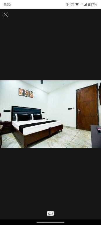 a bedroom with a bed and a wooden cabinet at Hotel Eden La in Dera Bassi