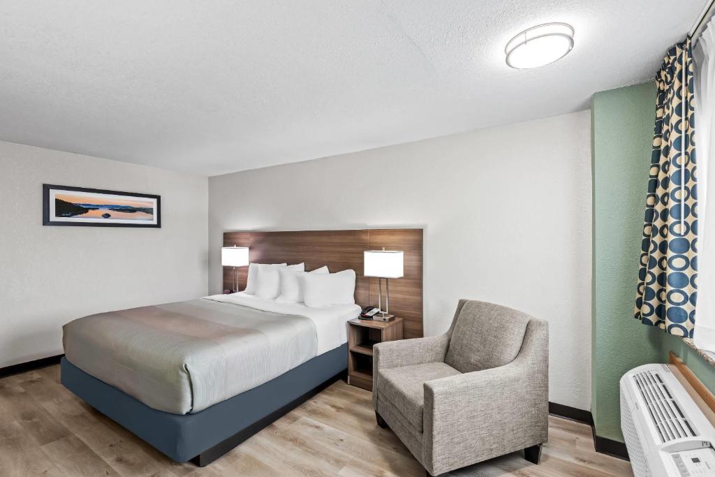 ein Hotelzimmer mit einem Bett und einem Stuhl in der Unterkunft Quality Inn in West Des Moines