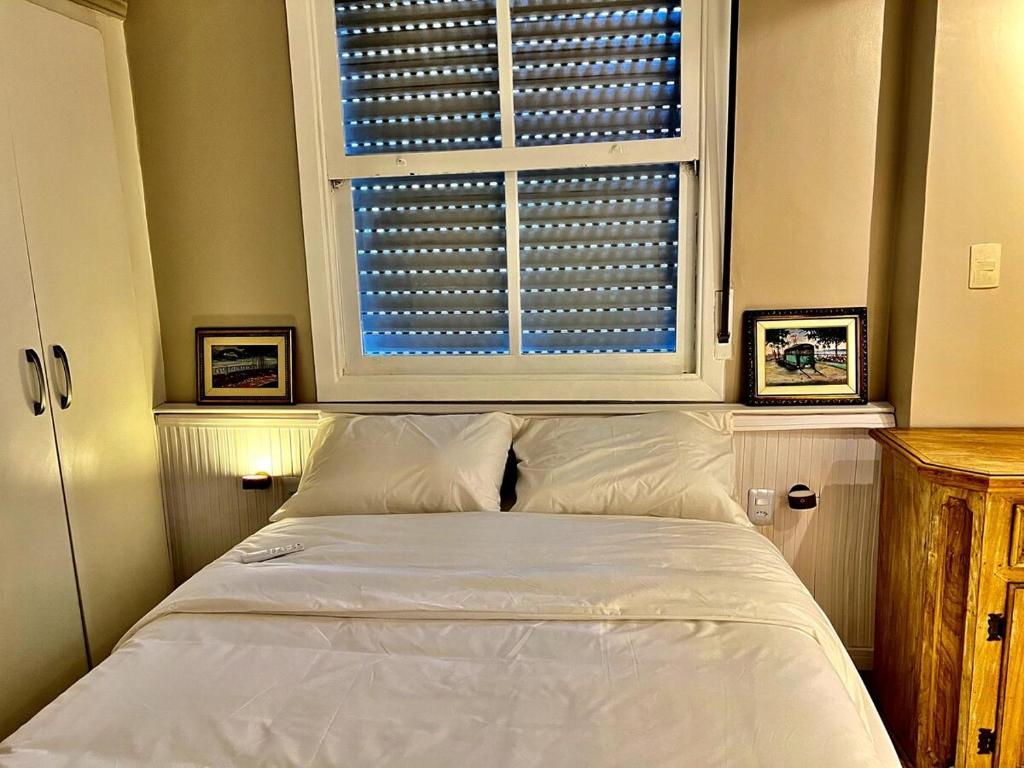 Un dormitorio con una cama blanca y una ventana. en Cozy, comfortable ocean view apartment for 4 people, en Santos