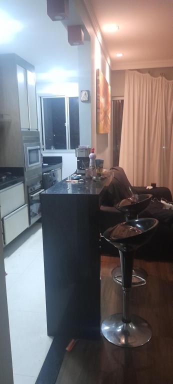 een keuken en woonkamer met een tafel en een bank bij Dois Quartos Completo in Vila Velha