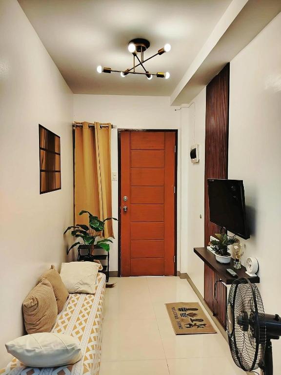 a living room with a red door and a couch at Marinduque Apartment in Tagum