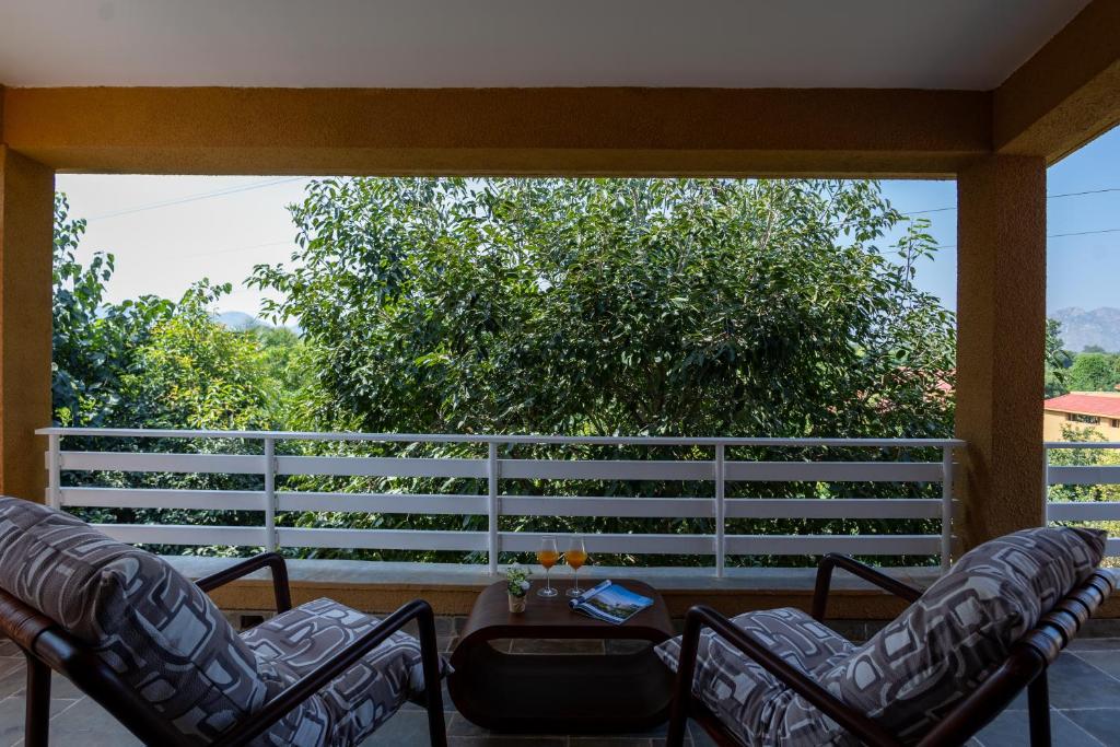eine Veranda mit Stühlen und einem Tisch und einem Zaun in der Unterkunft Viresco by Alaya Stays in Thūr