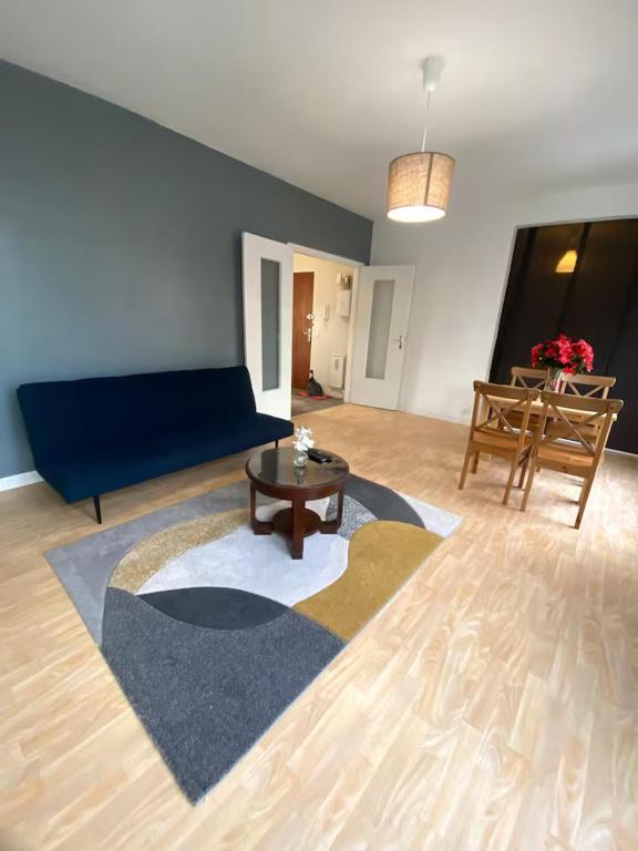 ღ Le Quai - T3 Proche Centre Ville & Gare في دويه: غرفة معيشة مع أريكة زرقاء وطاولة