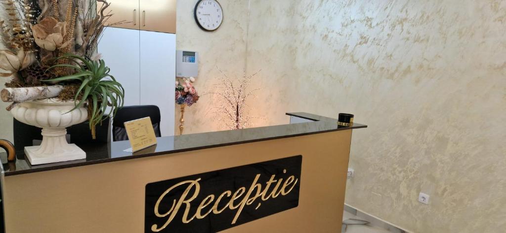 a reception counter in a room with a clock on the wall at Complex Lebada Botosani in Botoşani