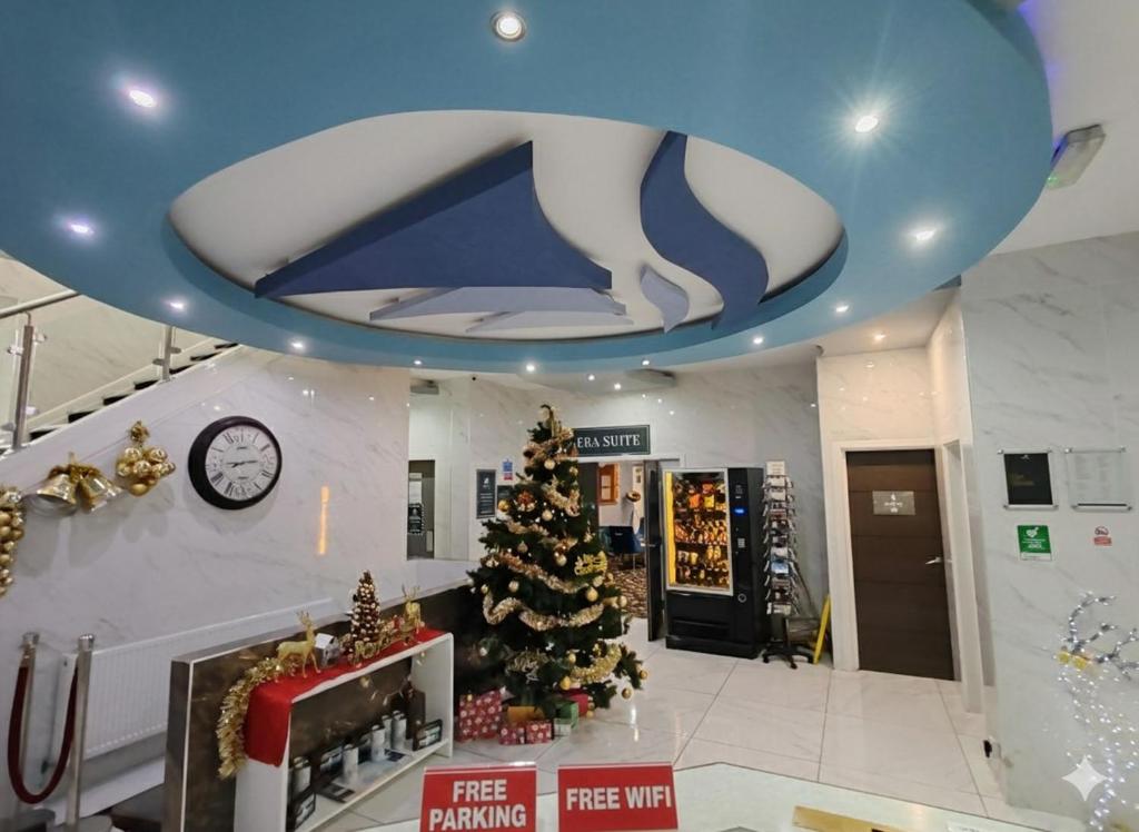 ein Zimmer mit einem Weihnachtsbaum und einer blauen Decke in der Unterkunft Torbay Court Hotel in Paignton