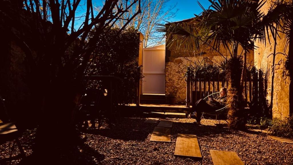 a person sitting on a swing in a yard at Studio 2 à 4 personnes in Dompierre-sur-Mer