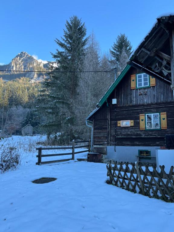 a wooden cabin in the snow with a fence at Ferienhütte Admont in Admont
