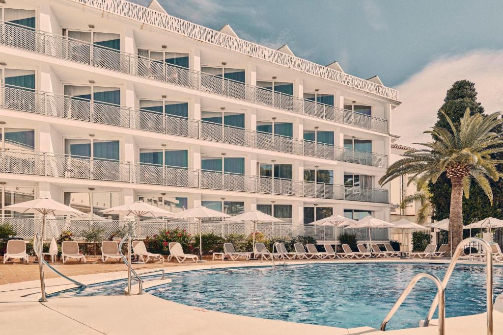 a hotel with a swimming pool in front of a building at Beneste Villa Flamenca Hotel in Nerja