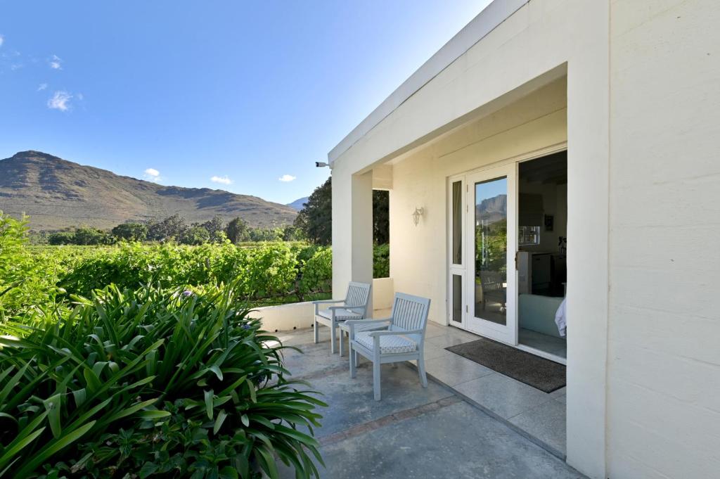 a patio with two chairs and a table on a house at The Little Vineyard Cottage in Franschhoek